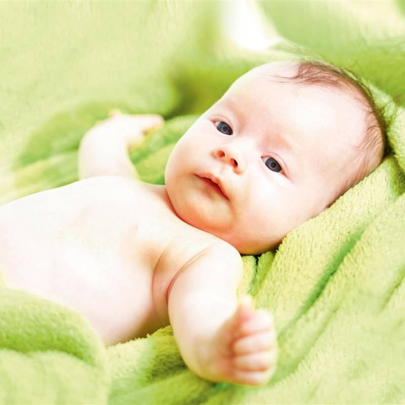 Bebé sobre toalla verde