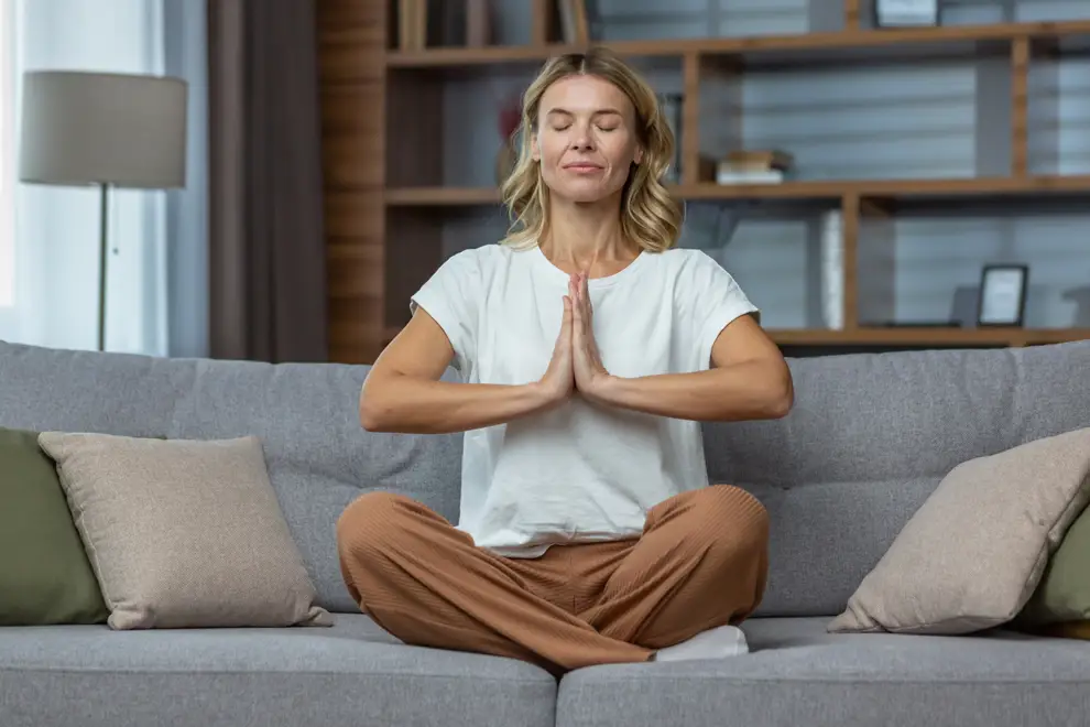 mujer meditando sofa