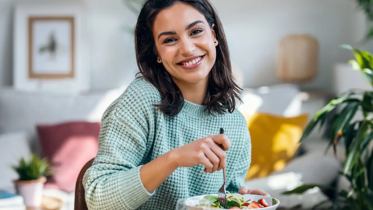 Mujer joven plano medio comiendo sano