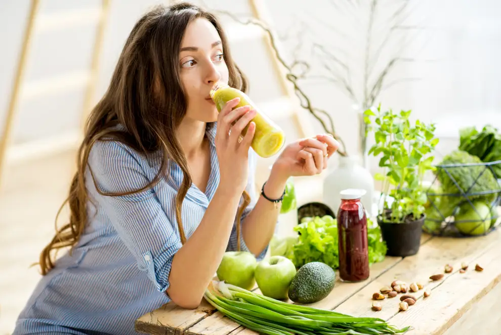 woman drinking green juice detox vegetables