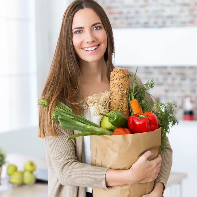 Mujer con bolsa llena hortalizas