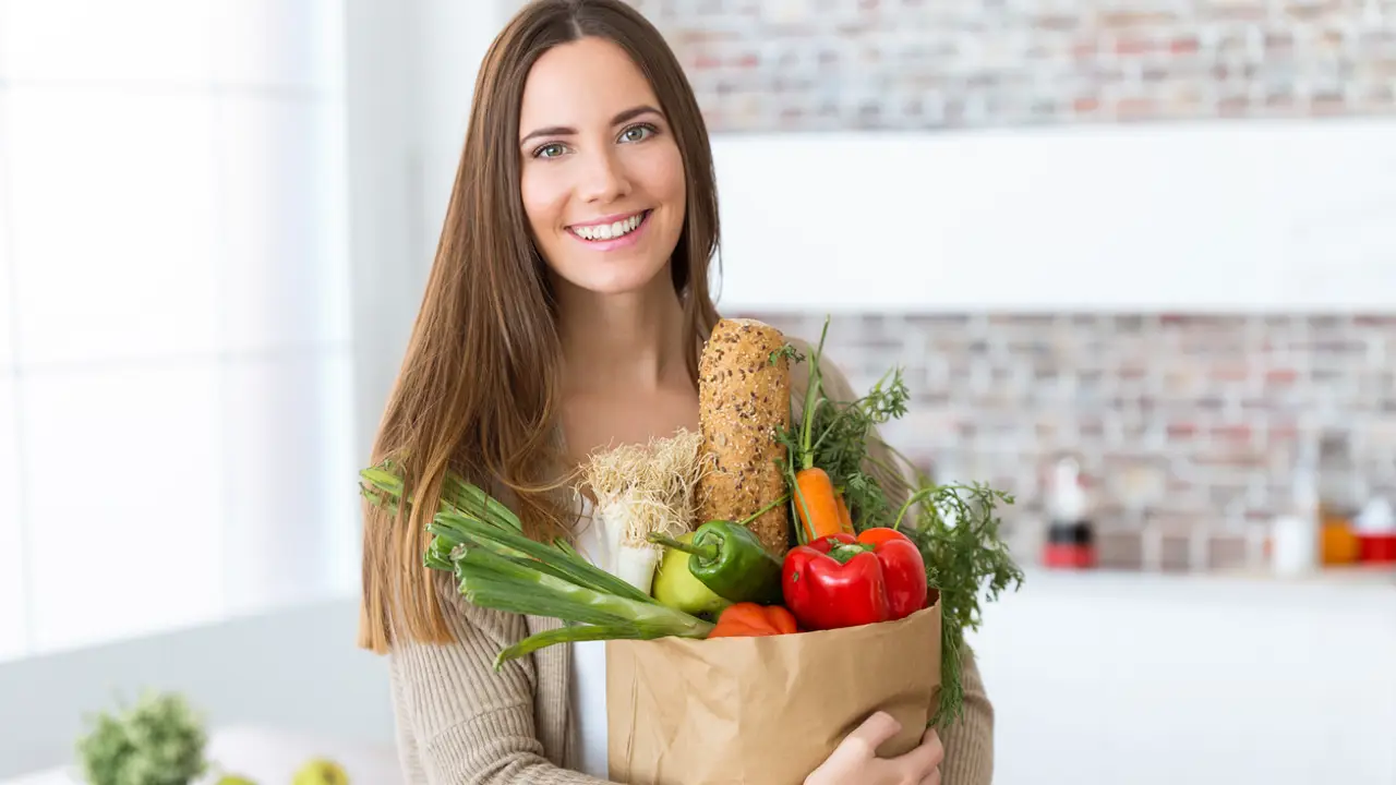 Mujer con bolsa llena hortalizas