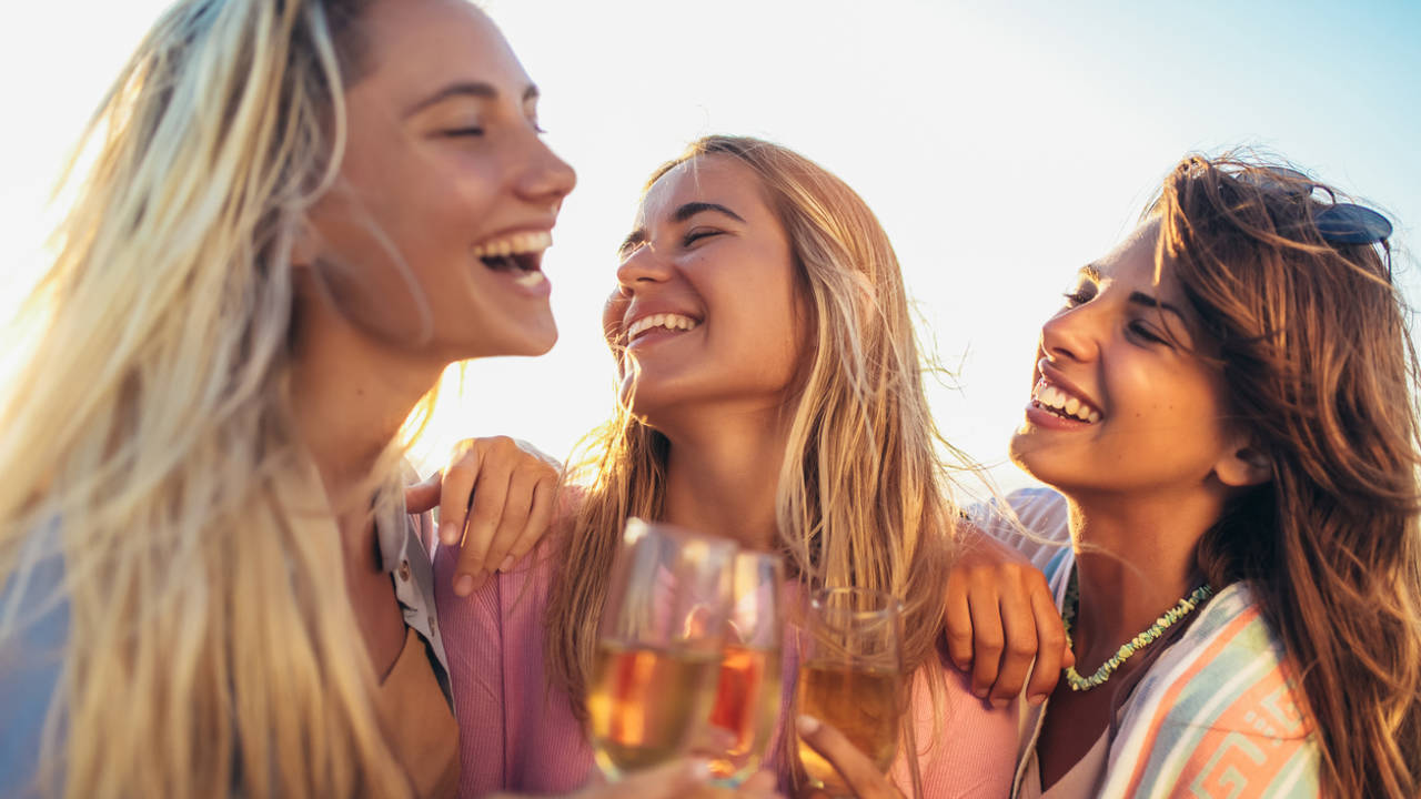 mujeres jovenes felices bebiendo vino alcohol