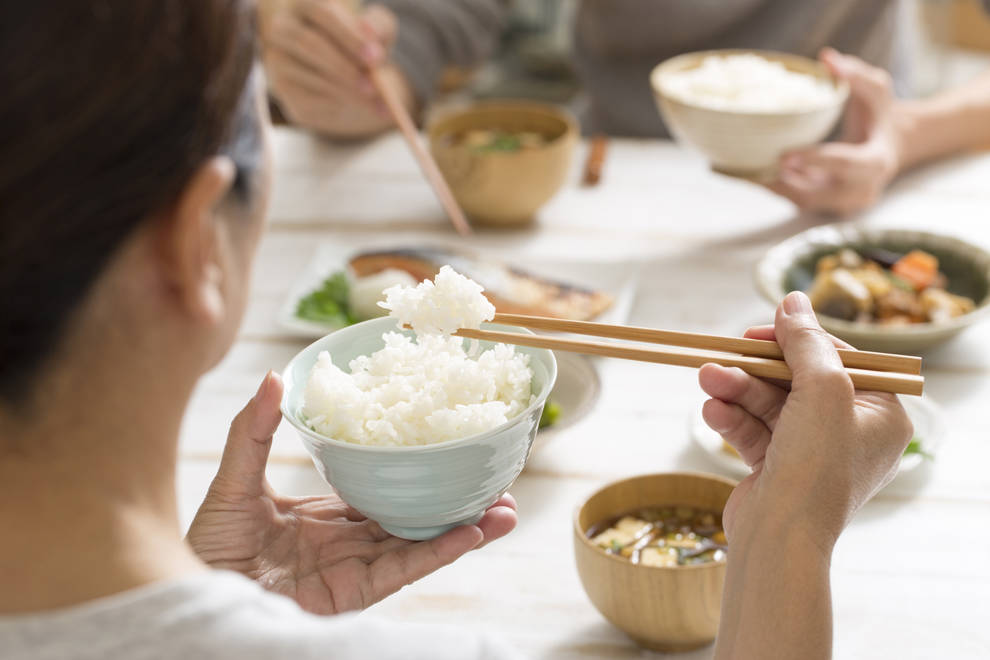 mujer comiendo bol arroz con palillos comida japonesa