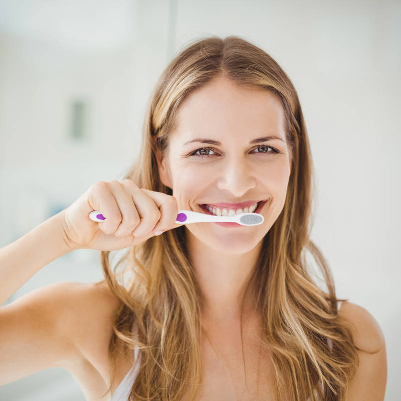 Mujer lavandose los dientes