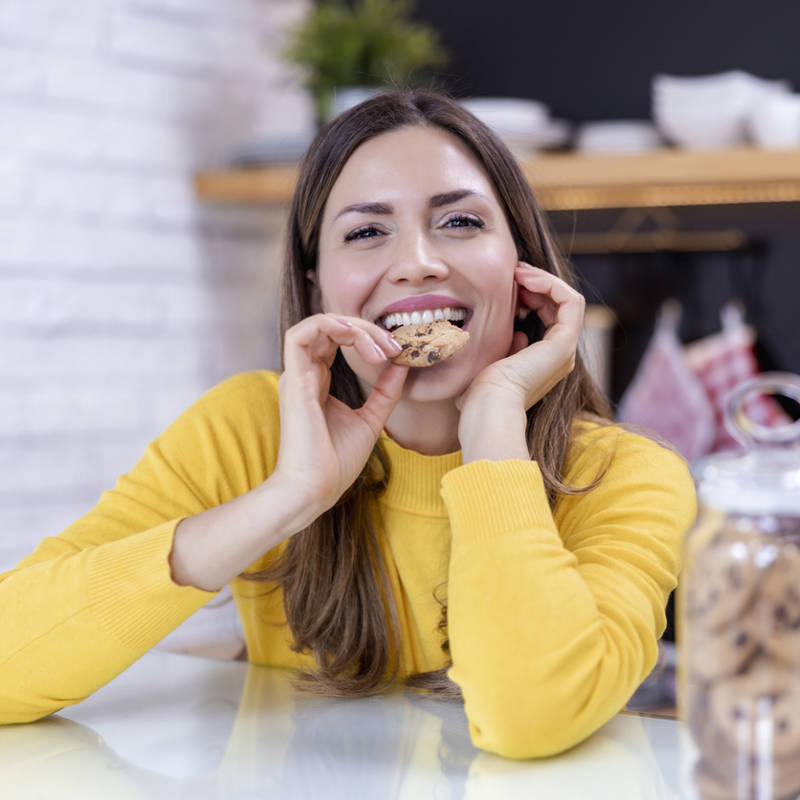 mujer joven comiendo galleta sana