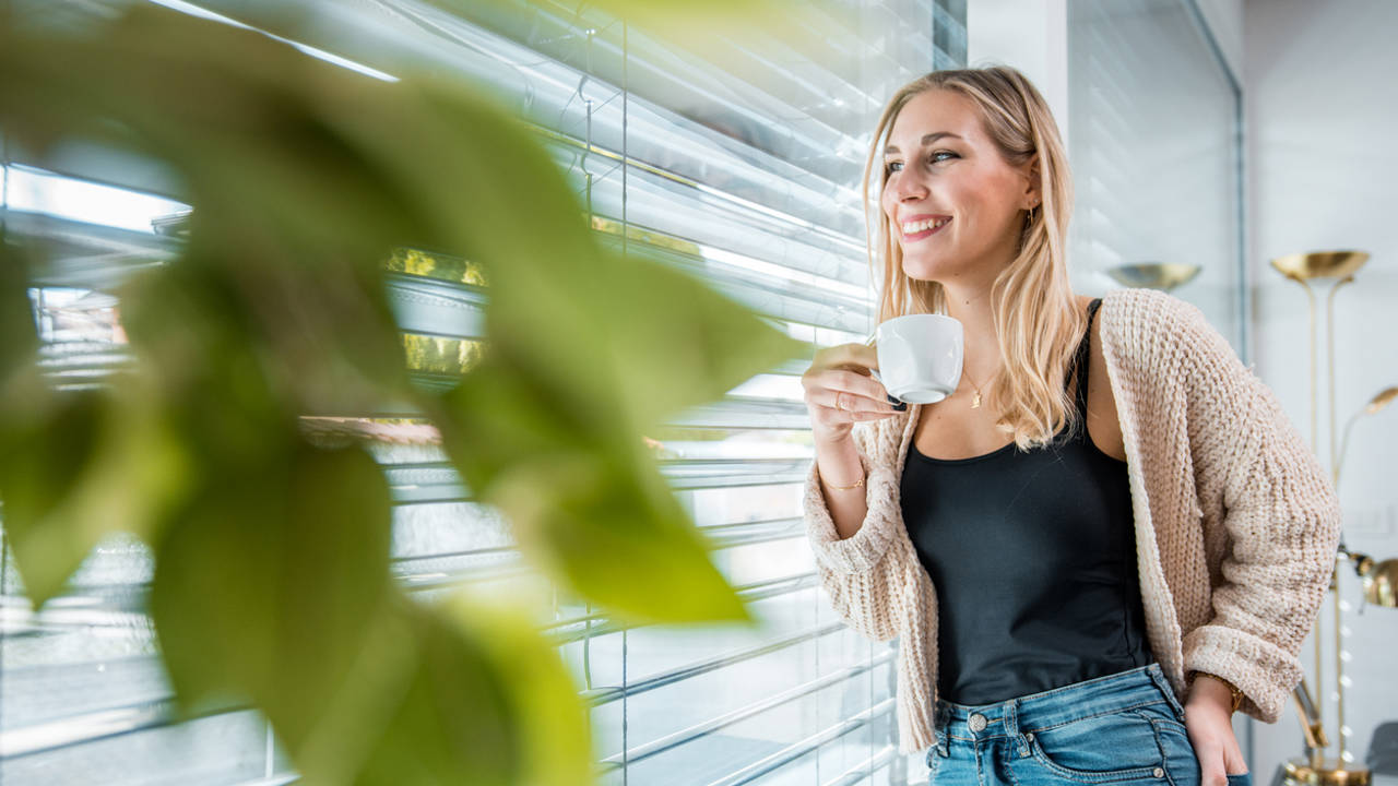 mujer joven sonriente oficina mirando por la ventana