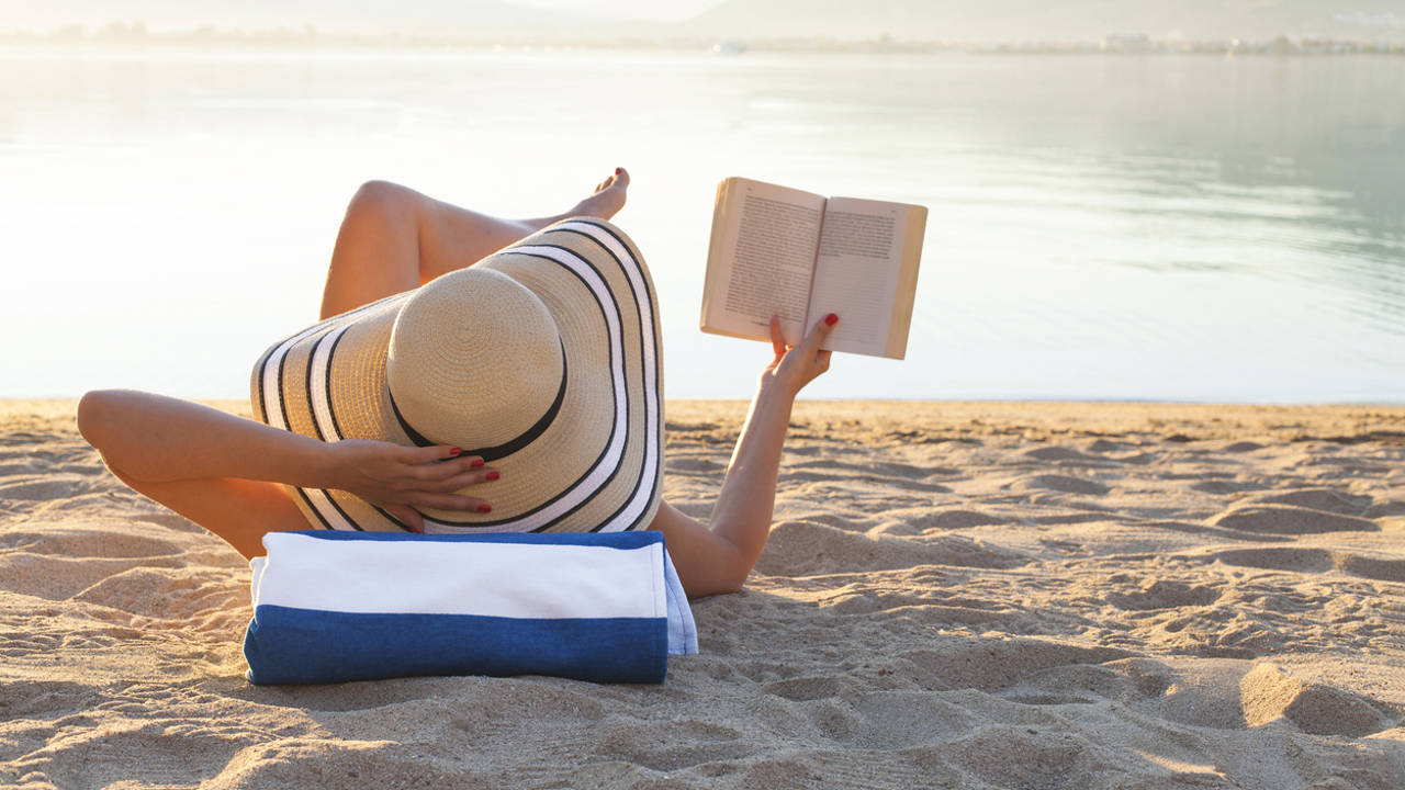 mujer leyendo en la playa