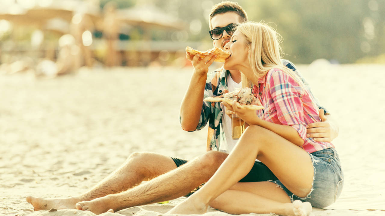 pareja comiendo en la playa