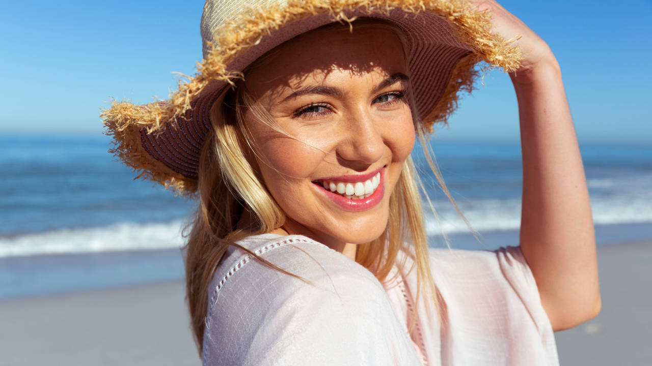 Chica al sol playa sombrero