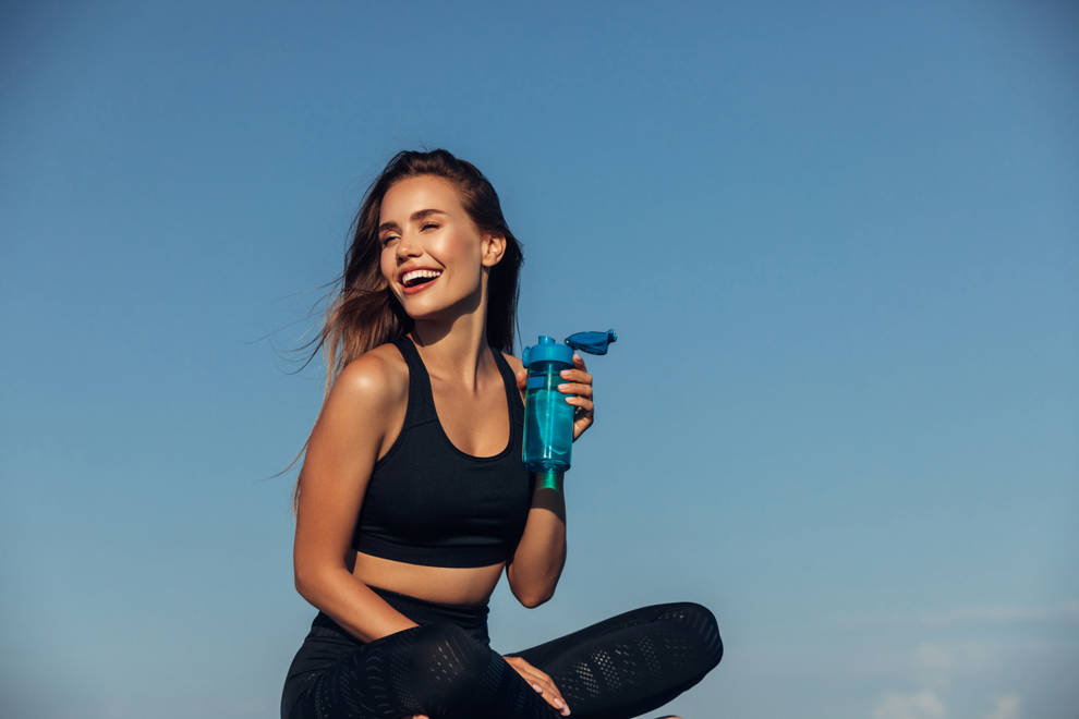 mujer joven ejercicio bebiendo agua