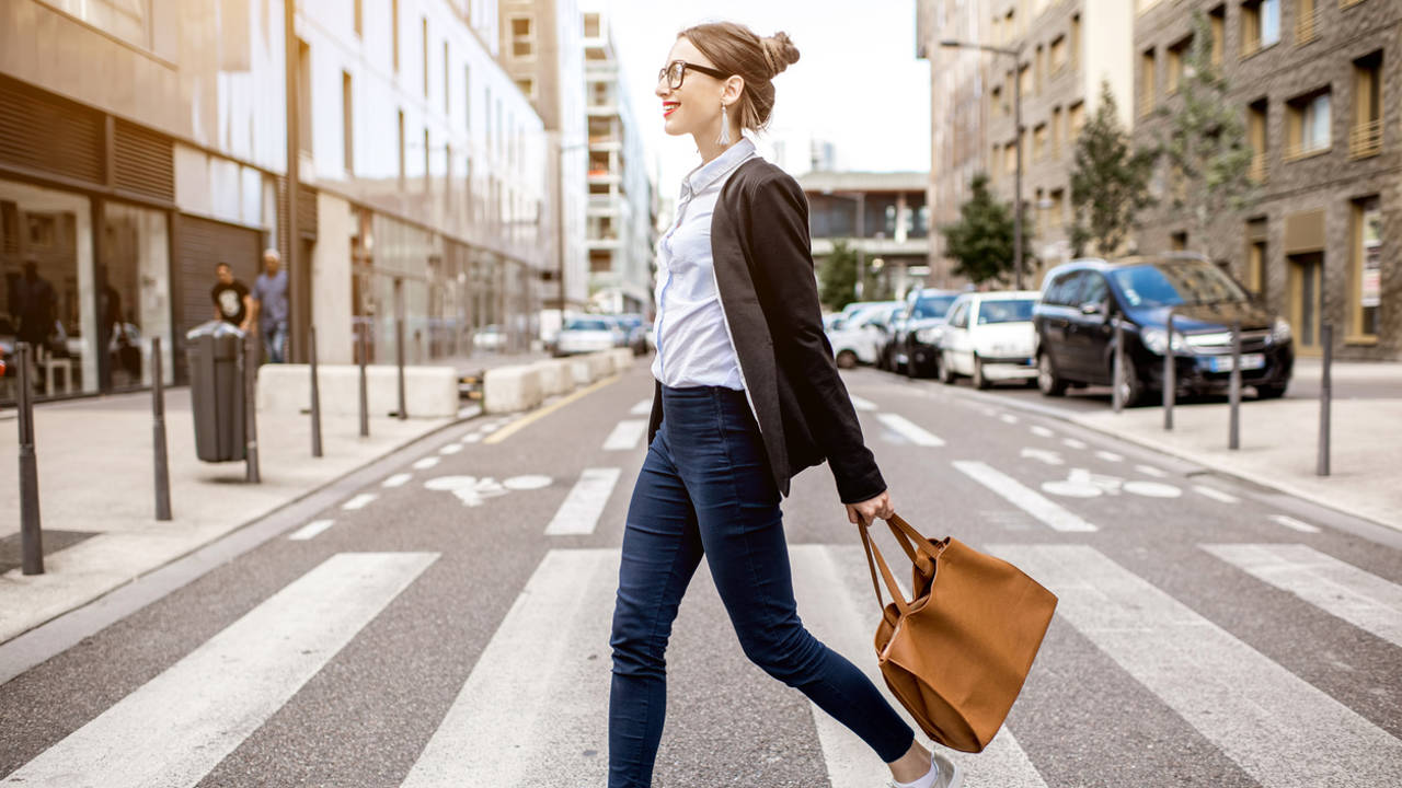 mujer caminando recto por la ciudad