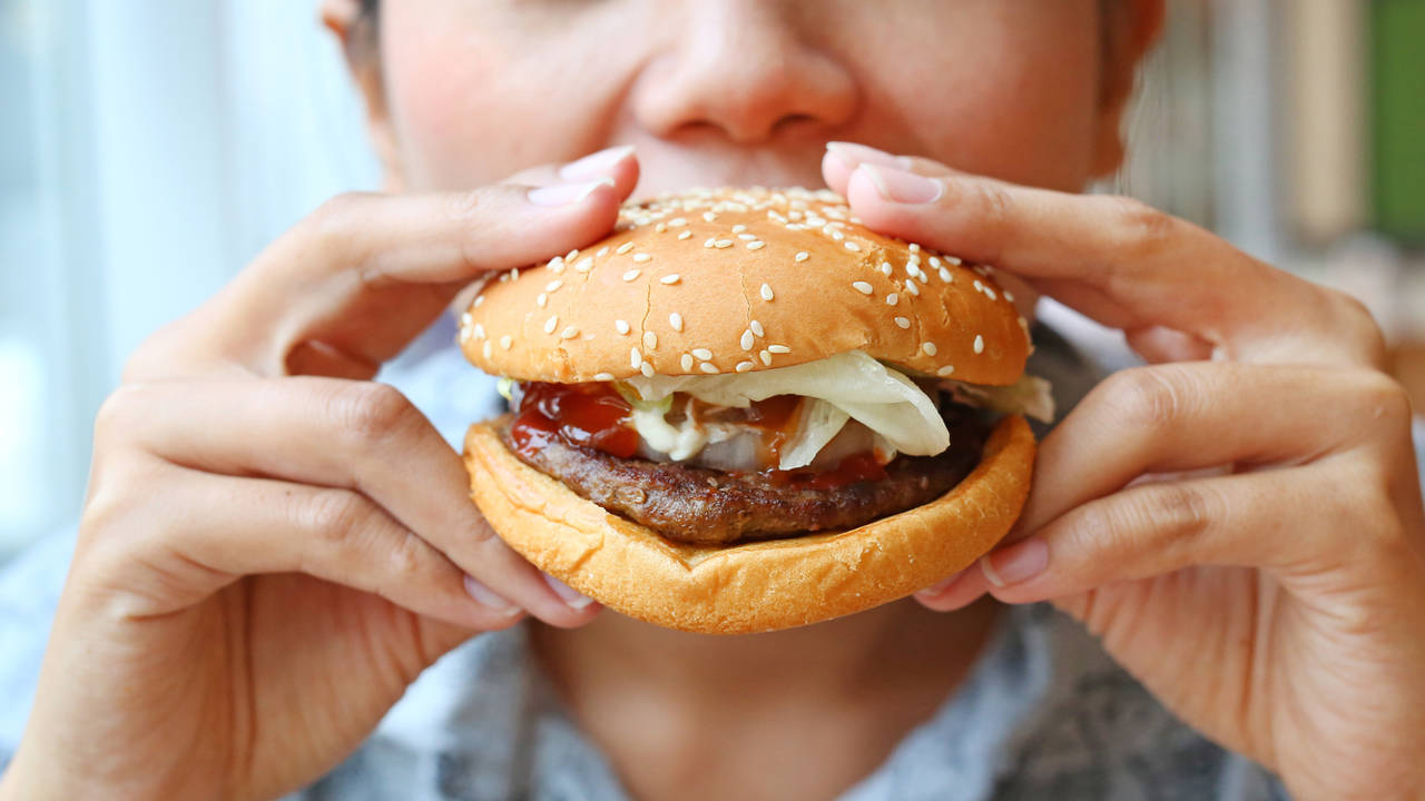 Mujer comiendo hamburguesa