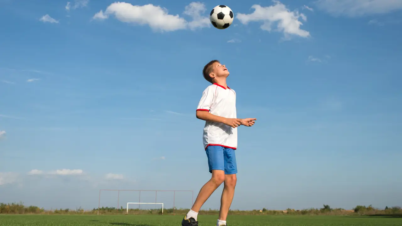 niños futbolista remate balón cabeza