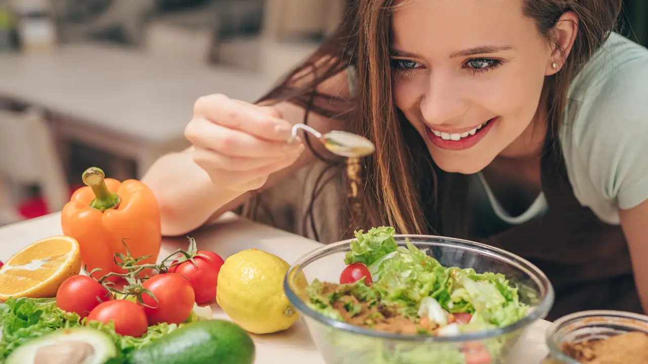 Chica aliñando ensalada