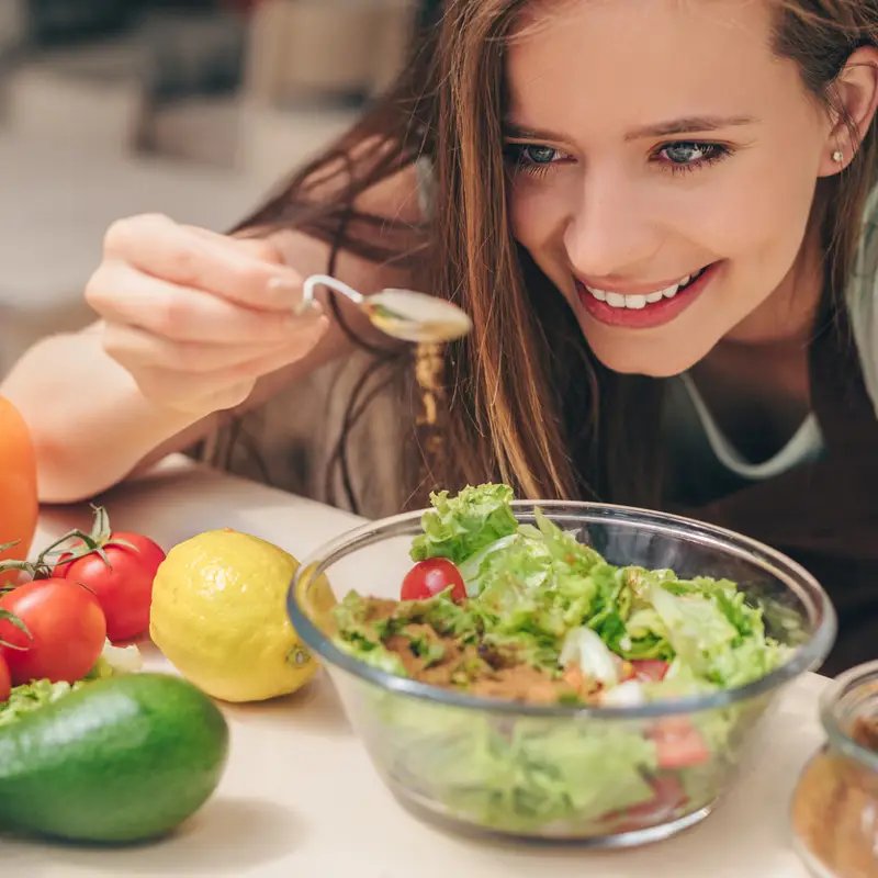 Chica aliñando ensalada