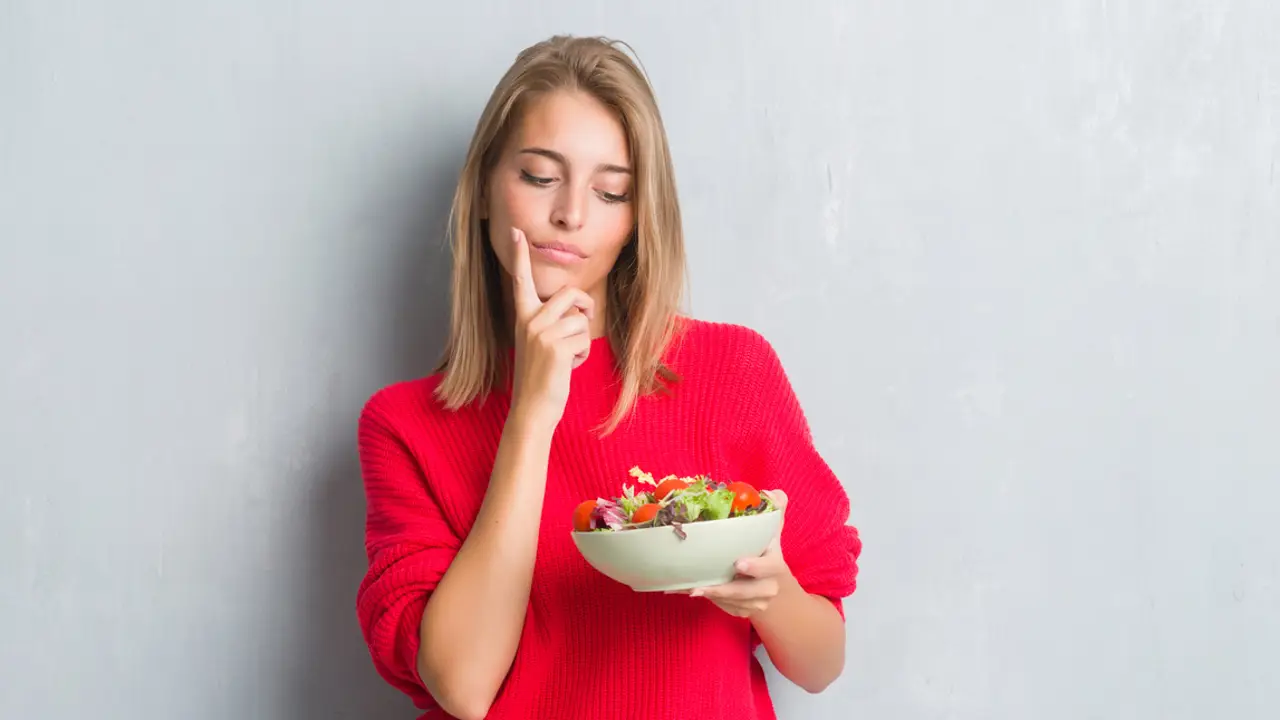 Chica pensando con ensalada