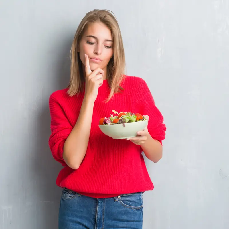 Chica pensando con ensalada