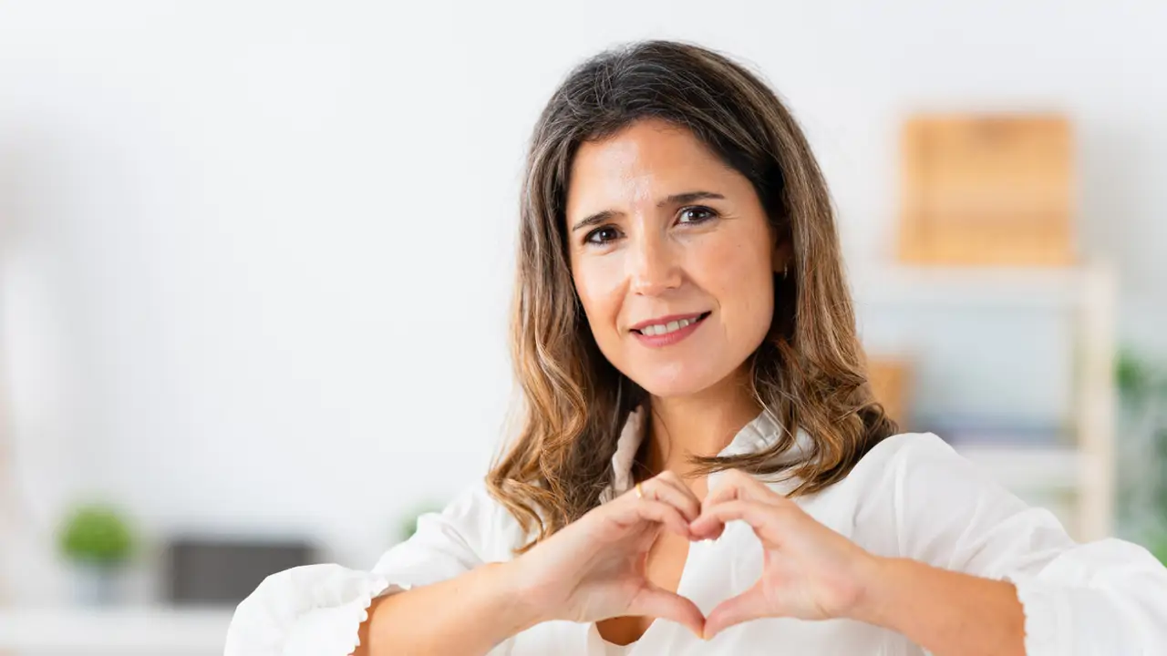 Mujer gesto corazón con las manos