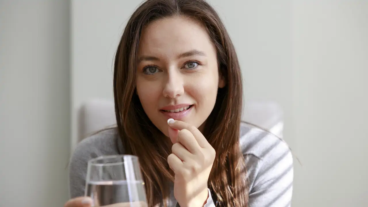 Mujer tomando pastilla