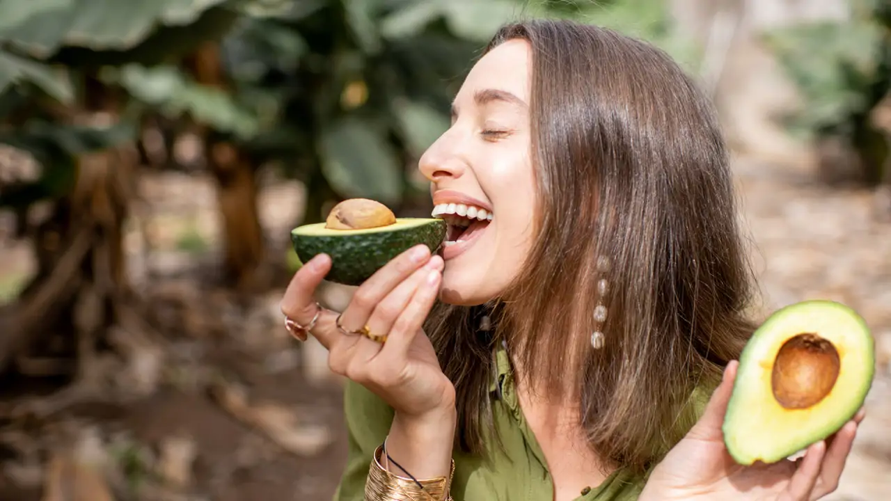 Mujer comiendo un aguacate