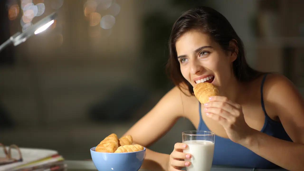 Mujer cenando cruasán