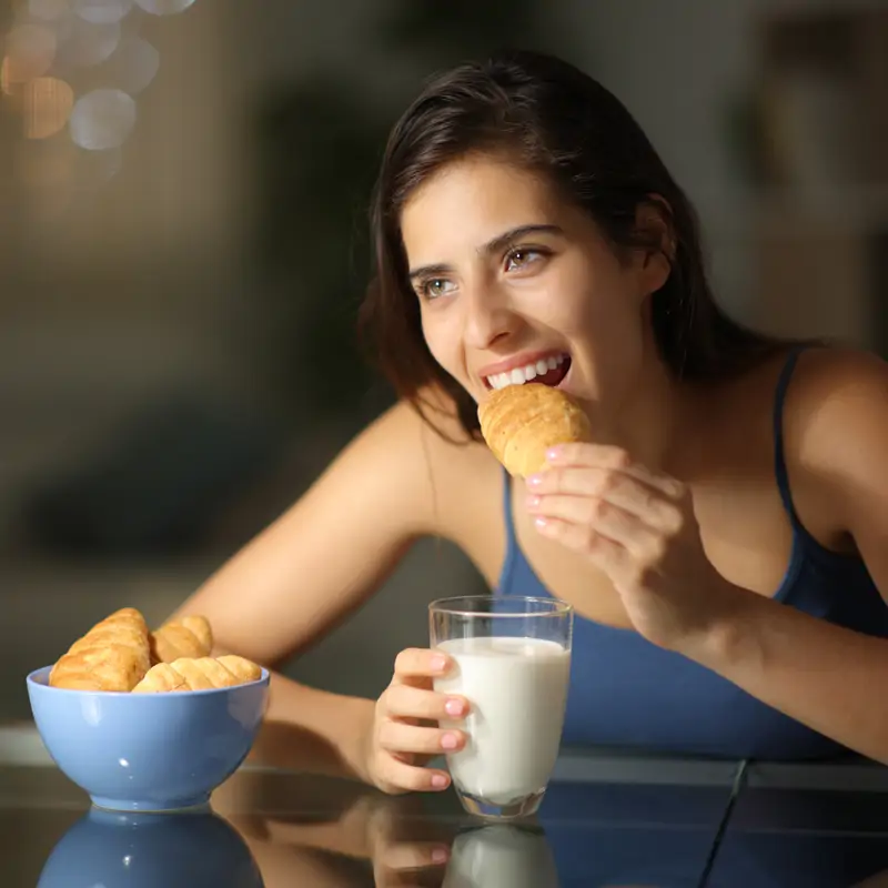 Mujer cenando cruasán