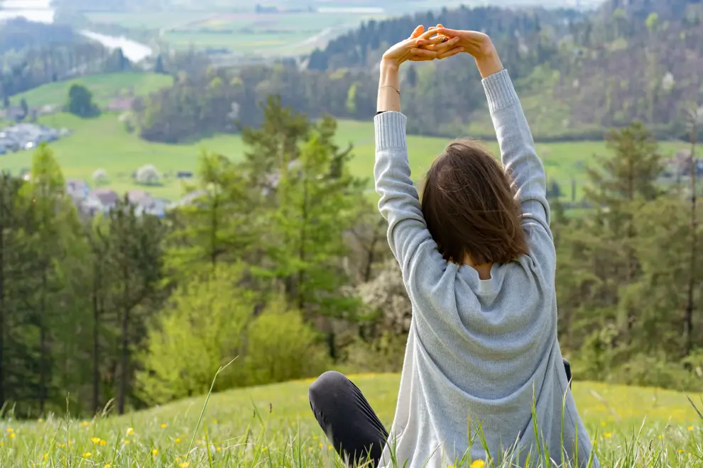 mujer relajada en plena naturaleza sentada en el campo