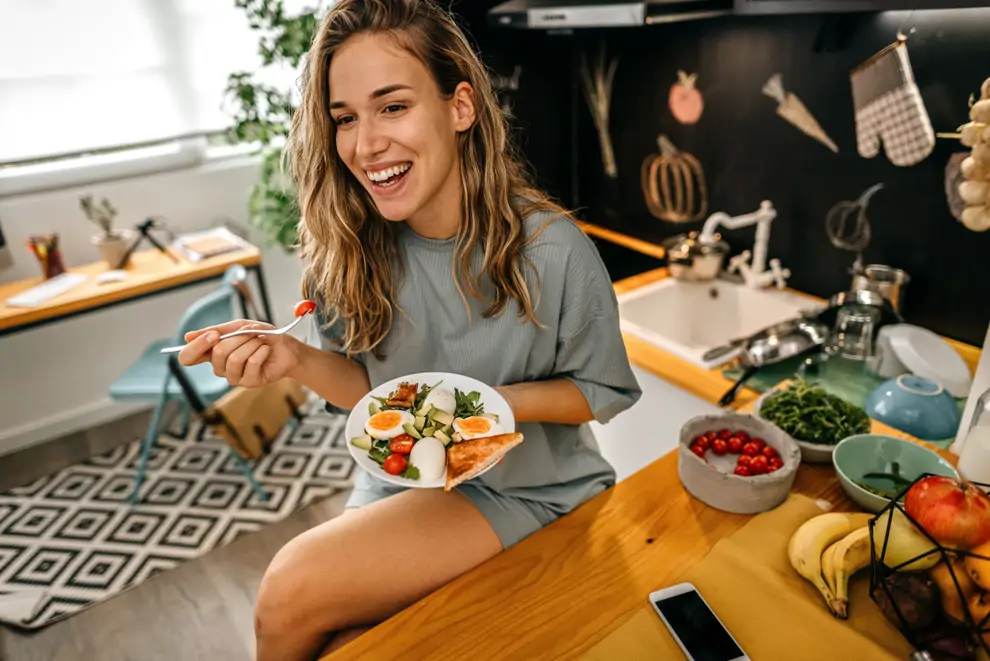 mujer joven comiendo verduras huevo plato sano desayuno