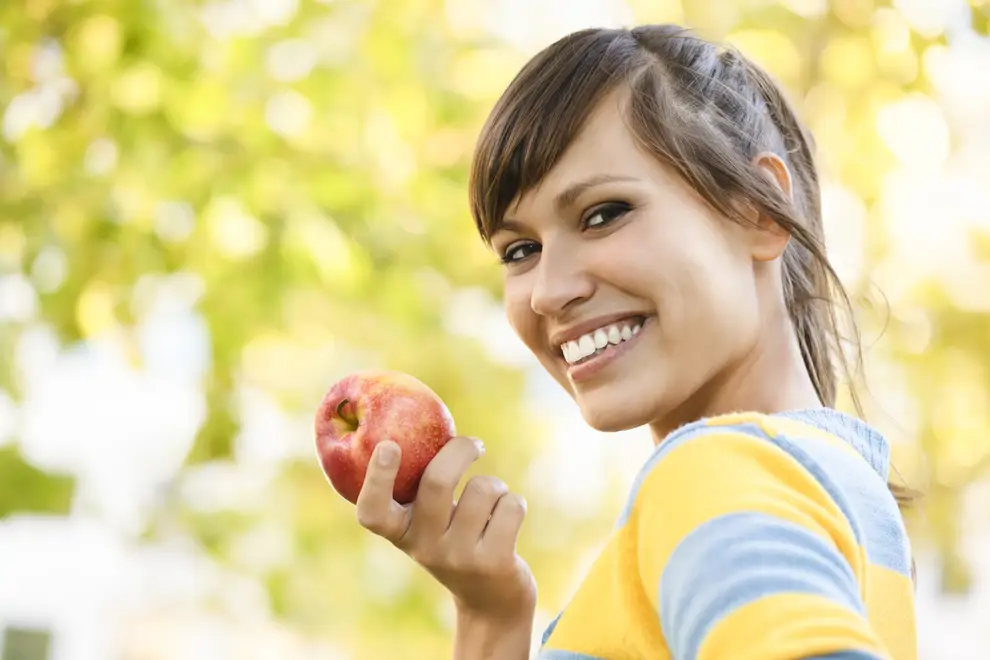 MUJER JOVEN GUAPA COMIENDO MANZANA