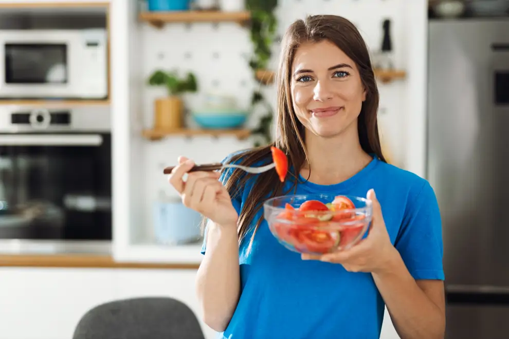 mujer comiendo tomate