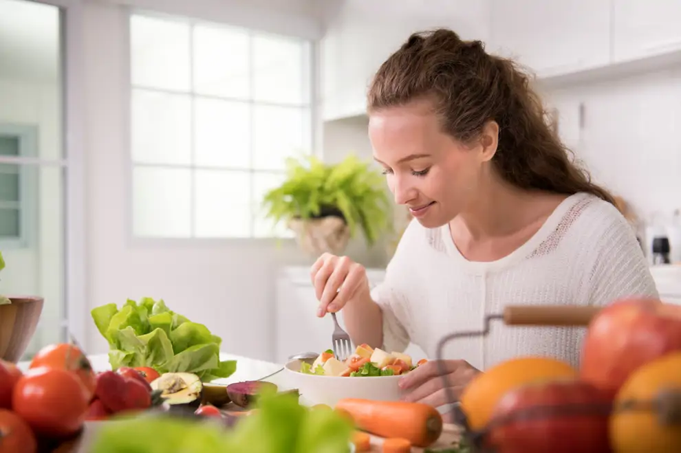 Mujer joven sana come ensalada