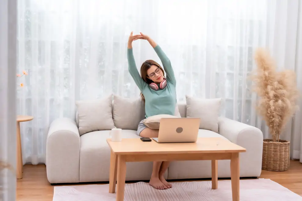 Mujer realiza estiramiento en el sofá