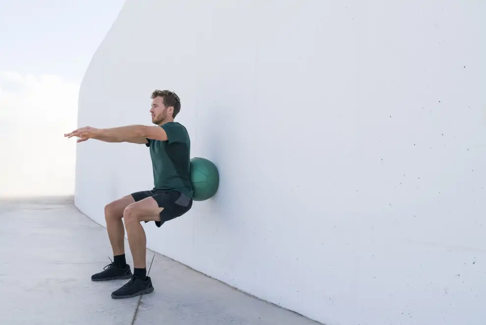 Sentadilla con balón suizo contra la pared