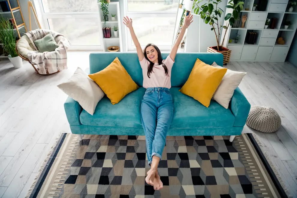 Mujer feliz en el sofá de su casa