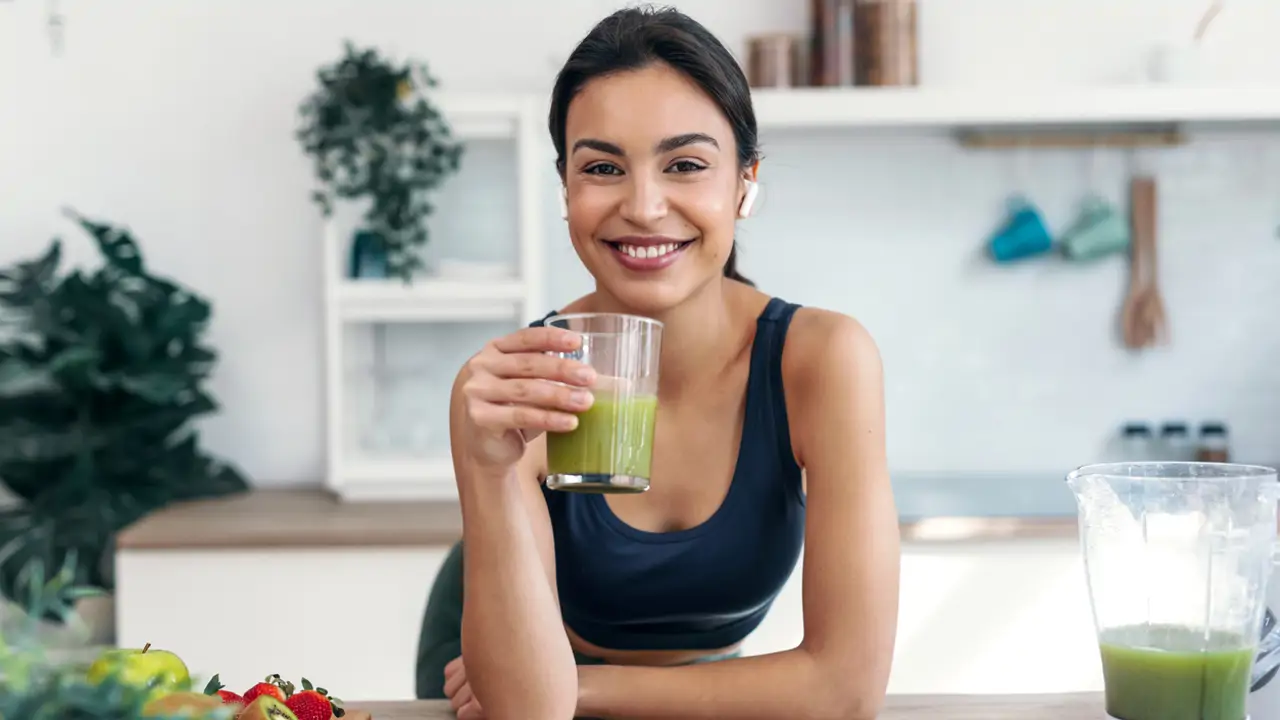 Mujer bebiendo batido verde