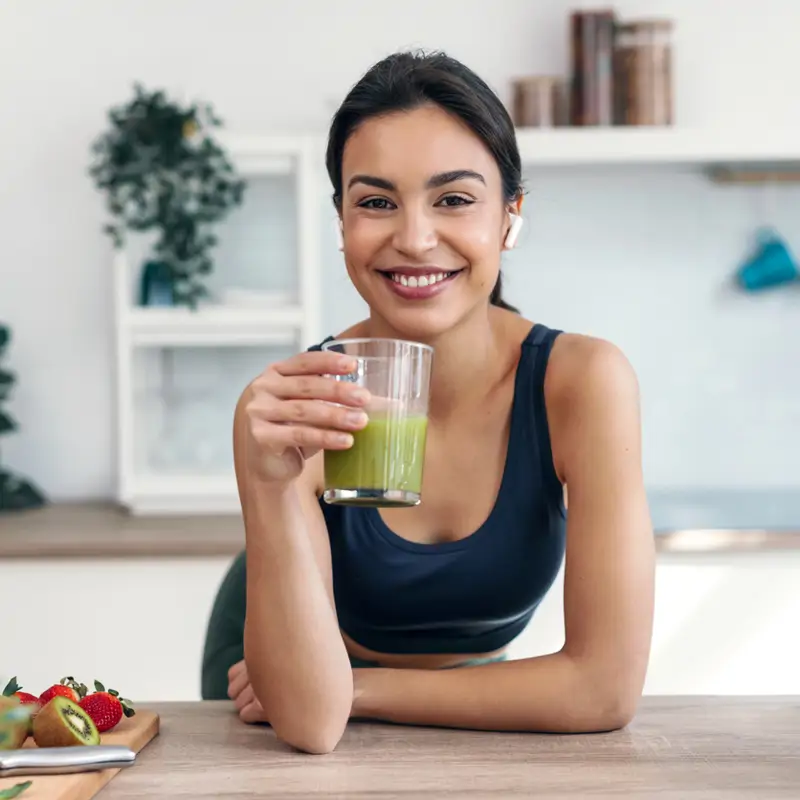 Mujer bebiendo batido verde