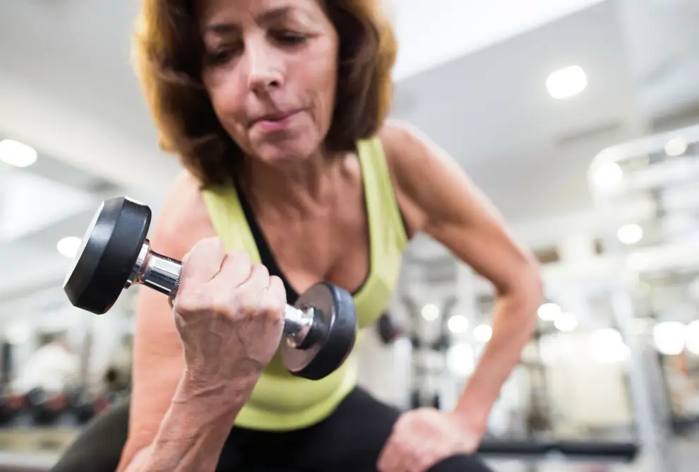 Mujer de 60 levantando pesas