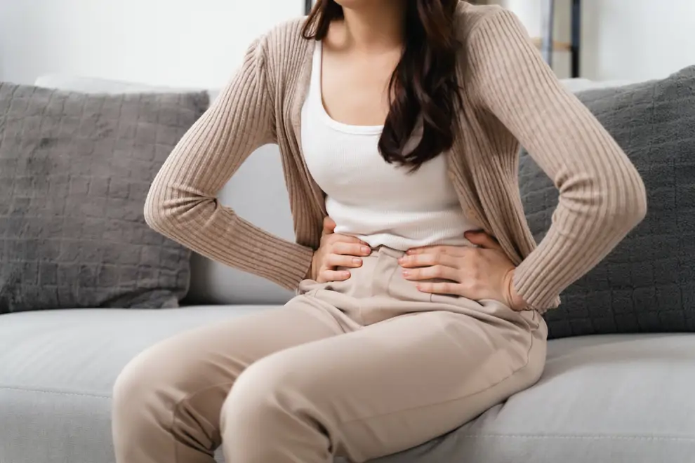 a mujer con dolor de estómago se sostiene el estómago con dolor