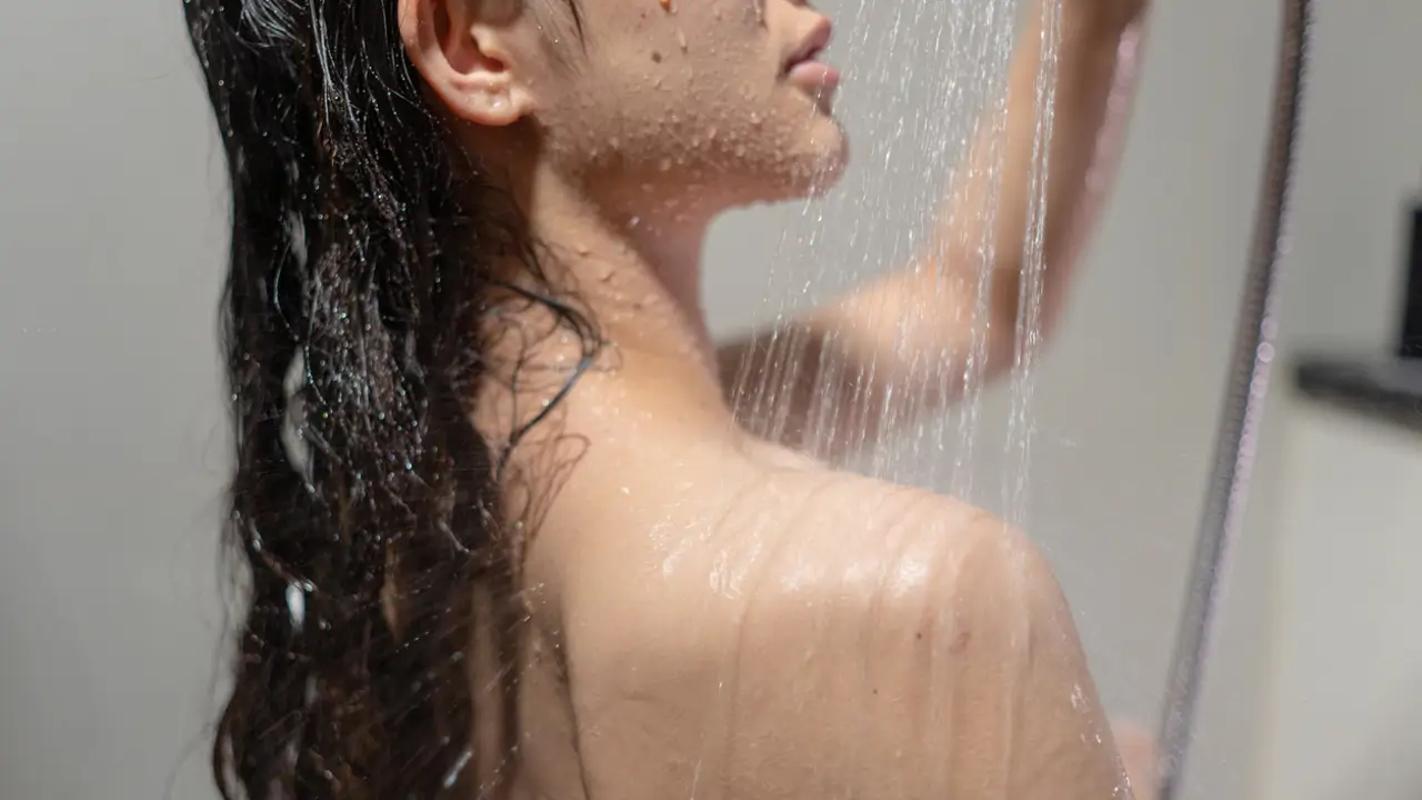Mujer bañándose y lavándose el pelo 