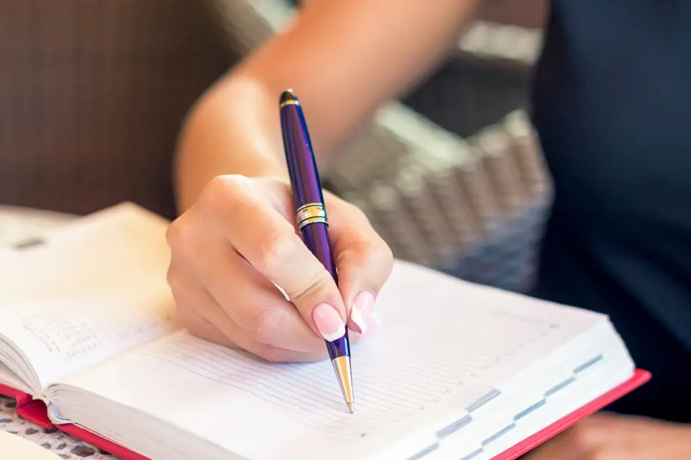 Mujer escribe a mano en el cuaderno